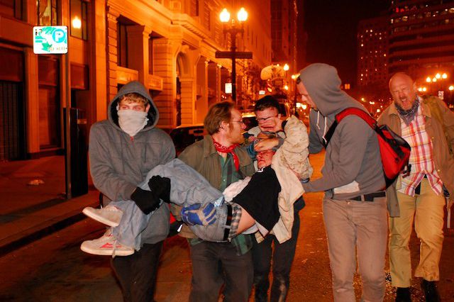 Protester and Iraq War Veteran Scott Olson is carried away from the chaotic scene last night